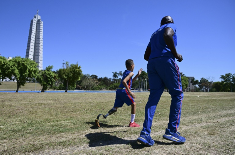Juan José Guilarte court avec son entraîneur, Albert Luis Campbell, pendant une session de pentathlon à La Havane, le 16 avril 2026 à Cuba ( AFP / YAMIL LAGE )