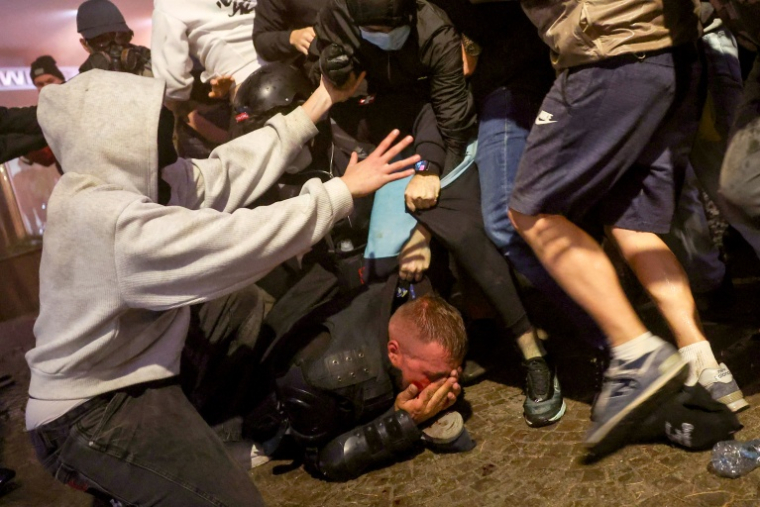 Des manifestants attaquent un policier lors d'affrontements dans le centre de Tirana le 14 octobre 2026 ( AFP / Adnan Beci )