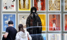 Des passants regardent la vitrine d'un magasin Moncler à Milan