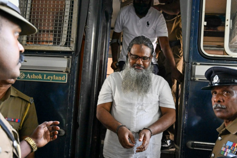 Des policiers escortent les accusés impliqués dans les attentats de Pâques 2019, lors du prononcé du verdict à la Haute Cour de Colombo, le 22 septembre 2026 au Sri Lanka ( AFP / Ishara S. KODIKARA )