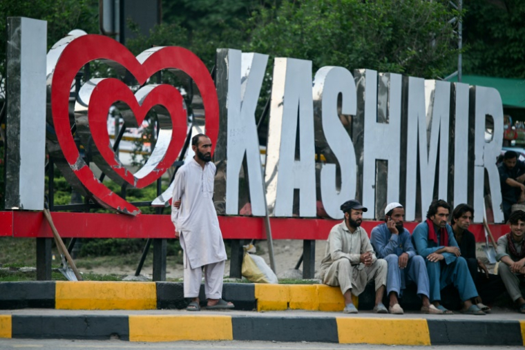 Des travailleurs assis au bord d'une route à Muzaffarabad, au Cachemire pakistanais, le 30 avril 2025 ( AFP / Farooq Naeem )