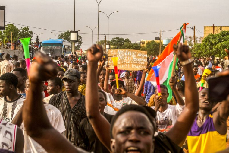 Photo de partisans de la junte nigérienne participant à une manifestation devant une base de l'armée française à Niamey