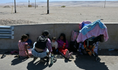Des migrants attendent près du poste frontière de Cachalluta avec le Pérou, à environ 25 km au nord d'Arica, au Chili, le 30 novembre 2025 ( AFP / RODRIGO ARANGUA )