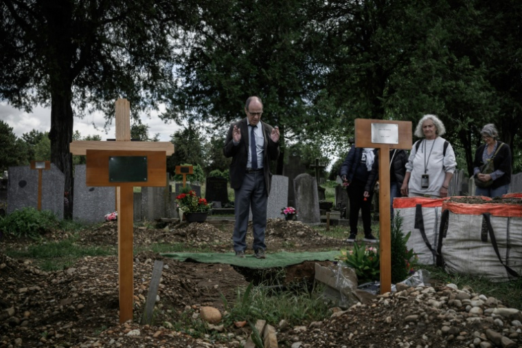 Des membres du collectif "Morts sans Toi(t)" se recueillent devant la tombe d'une personne décédée seule au cimetière de La Guillotière, le 11 mai 2026 à Lyon,dans le Rhône  ( AFP / Jeff PACHOUD )