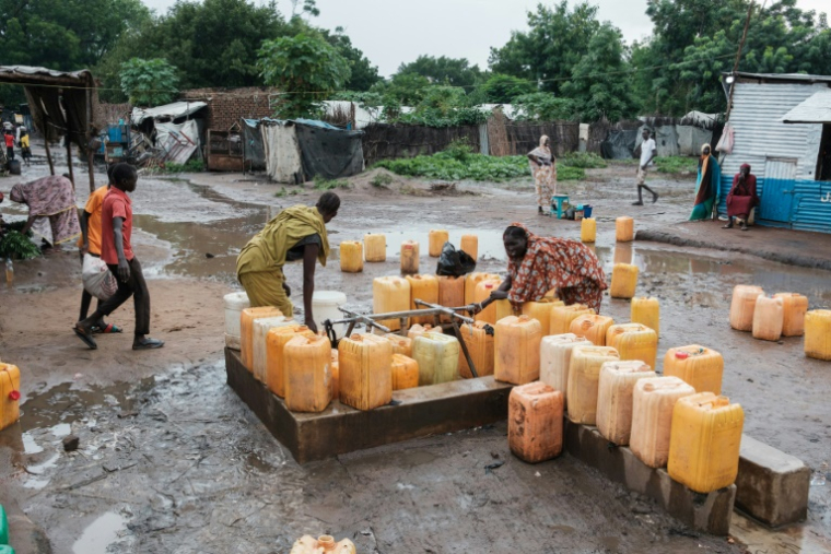 Des femmes remplissent des bidons d'eau à une pompe à Maban, le 20 août 2025 au Soudan du Sud ( AFP / GUY PETERSON )