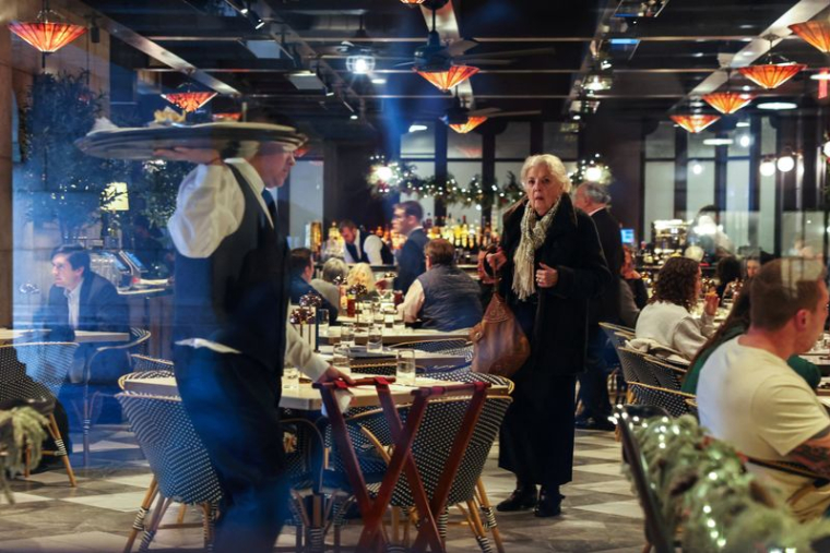 Une femme attend une table dans un restaurant de la gare de Grand Central