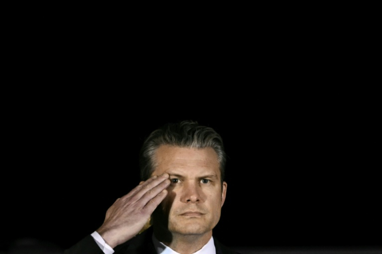 Le secrétaire américain à la Défense Pete Hegseth salue tandis que des membres d’une équipe de l’armée américaine transportent un cercueil de transfert recouvert d’un drapeau contenant la dépouille du sergent Benjamin N. Pennington, 26 ans, originaire de Glendale, lors d’une cérémonie solennelle de rapatriement à la Dover Air Force Base, à Dover, le 9 mars 2026 ( AFP / Brendan SMIALOWSKI )