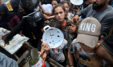 Des enfants se pressent à une distribution de repas chauds à Nousseirat, dans le centre de la bande de Gaza, le 4 juin 2025 ( AFP / Eyad BABA )