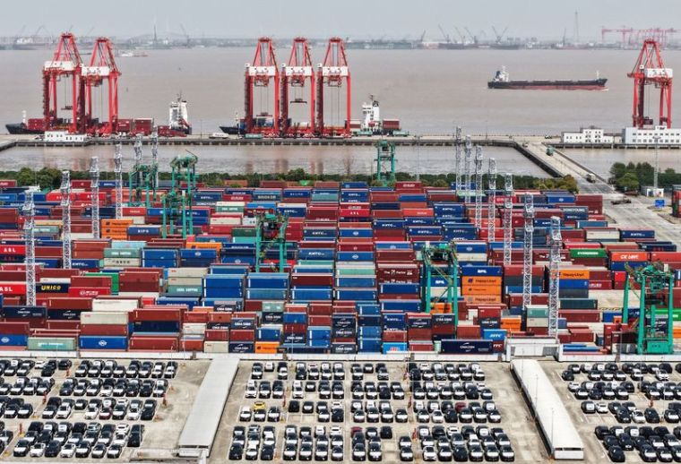 Une vue prise par drone montre des véhicules électriques (VE) destinés à l'exportation et des conteneurs amarrés dans un port de Shanghai