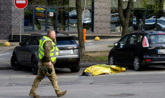 Un policier passe devant le corps d'une victime d'une fusillade près d'un supermarché de Kiev, la capitale ukrainienne, le 18 avril 2026 ( AFP / Serhii Okunev )
