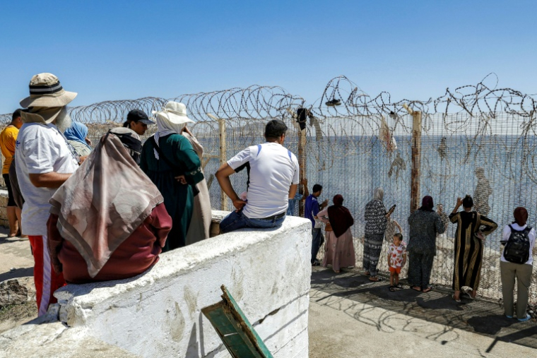 Des proches de migrants ayant traversé illégalement la frontière entre le Maroc et l'enclave espagnole de Ceuta attendent de leurs nouvelles, dans la ville marocaine de Fnideq le 2 août 2026 ( AFP / Abdel Majid BZIOUAT )