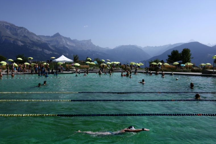 Des baigneurs dans le plan d'eau biotope de Combloux, en Haute-Savoie, le 12 août 2026 ( AFP / Alex MARTIN )