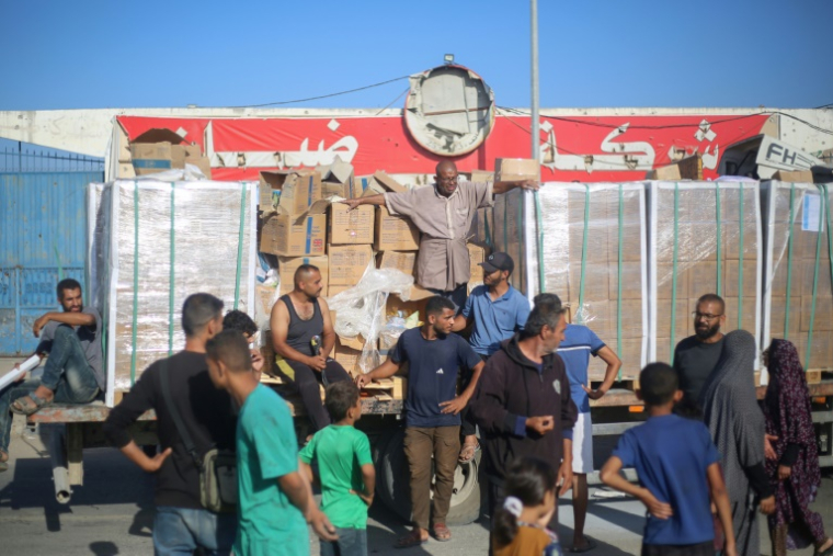 Des déplacés palestiniens se rassemblent autour d'un camion pour recevoir des vivres arrivés dans le camp de réfugiés de Nousseirat, dans le centre de la bande de Gaza, le 20 octobre 2025 ( AFP / Eyad BABA )