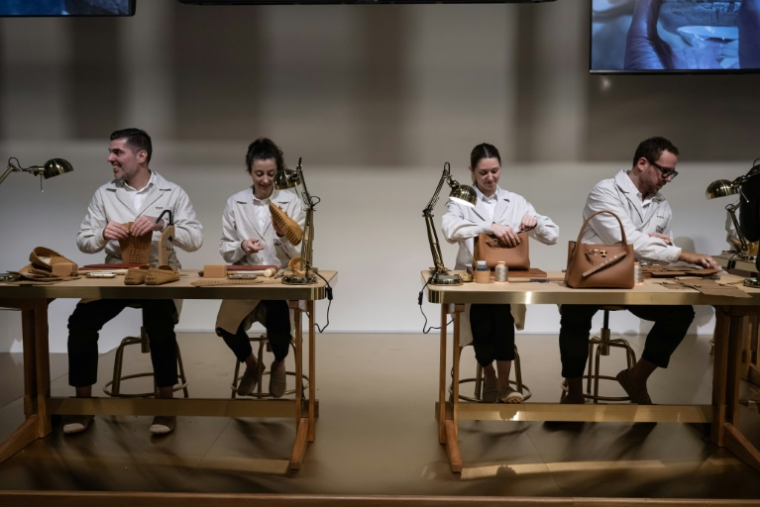 A l’entrée du défilé Tod’s à Milan, des artisans réalisent des articles en cuir et des broderies "Made in Italy", le 27 février 2026 ( AFP / MIGUEL MEDINA )