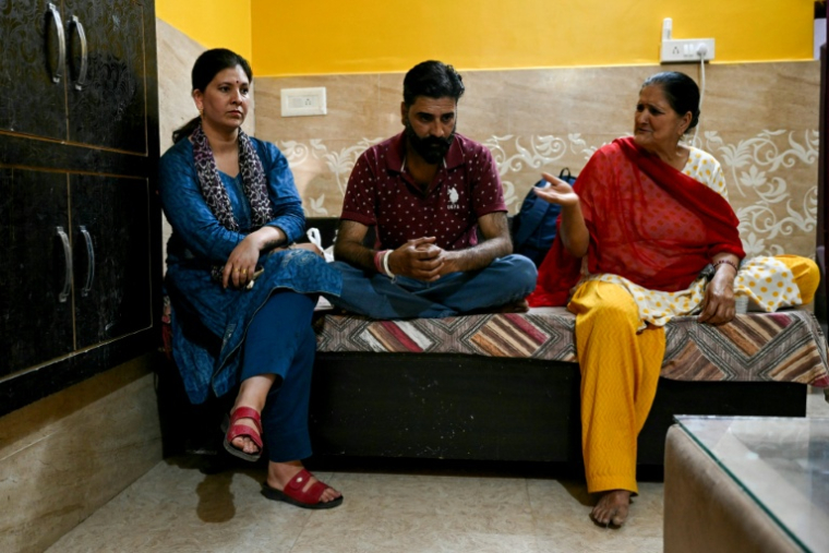 Shruti Sharma (à gauche), qui a fui son domicile de Poonch, au Cachemire indien, est assise avec son mari Sandeep Sharma (au centre) et sa belle-mère Champa Devi après son retour, le 14 mai 2025 ( AFP / Money SHARMA )
