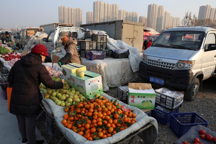 Un vendeur de fruits s'occupe d'un client sur un marché en plein air à Pékin, Chine