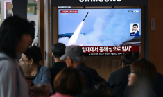 Un écran diffuse des images d'archives de missiles nord-coréens, le 19 avril 2026 dans une gare de Séoul ( AFP / Jung Yeon-je )