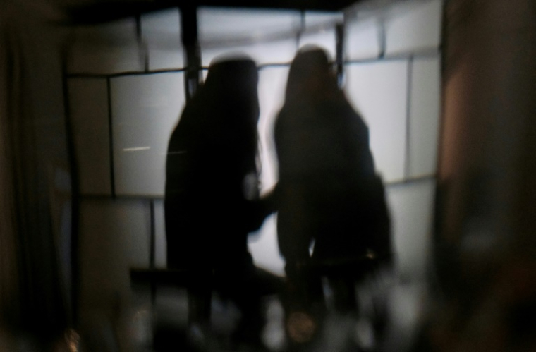 Des étudiantes de l'université de Hong Kong victimes de deepfakes pornographiques - B. et C. - regardent leur téléphone, le 29 juillet 2025 à Hong Kong ( AFP / Tommy WANG )