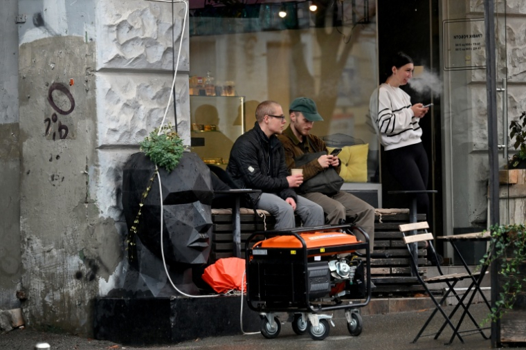 Un générateur en marche devant un café à Kiev durant une coupure de courant causée par des frappes russes sur des installations électriques, le 18 octobre 2026 ( AFP / Sergei SUPINSKY )