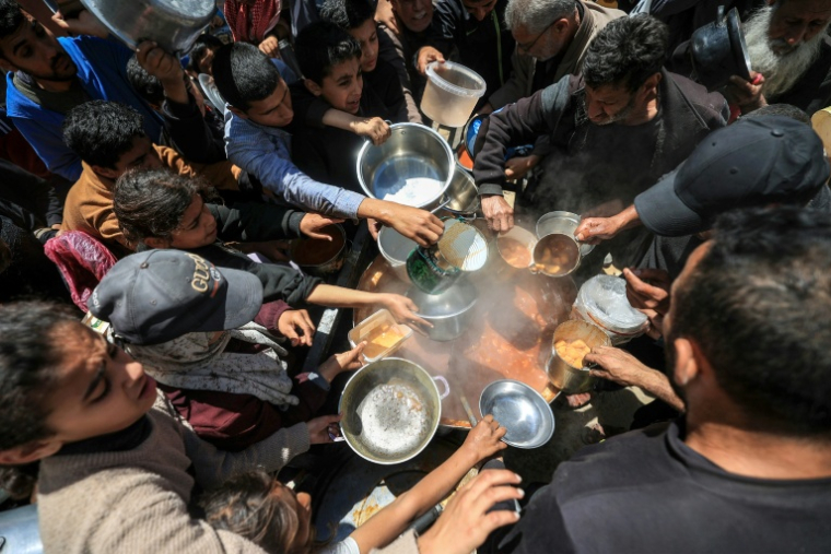 Des Palestiniens déplacés reçoivent de la nourriture dans le camp de réfugiés de Nuseirat, dans le centre de la bande de Gaza, le 22 avril 2026 ( AFP / Eyad Baba )