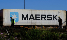 Des travailleurs alors qu'un conteneur Maersk est transporté par un train près d'un port de Barcelone
