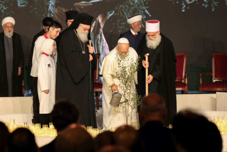 Le pape Léon XIV, entouré des dignitaires religieux libanais, arrose un olivier qu'il a planté dans le centre de Beyrouth, le 1er décembre 2025 ( AFP / anwar amro )