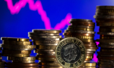 Des pièces en livres sterling sont visibles devant un graphique boursier affiché dans cette illustration