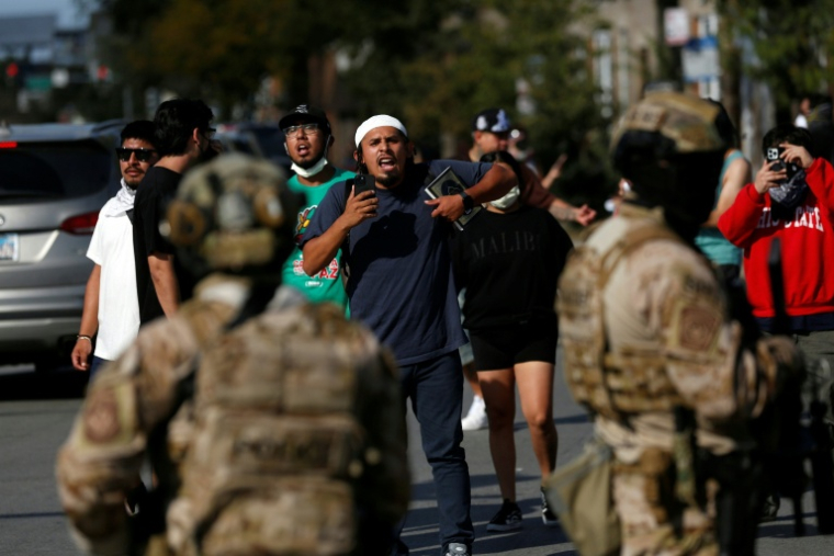 Un homme filme les forces de l'ordre à Chicago, le 4 octobre 2025 ( AFP / OCTAVIO JONES )