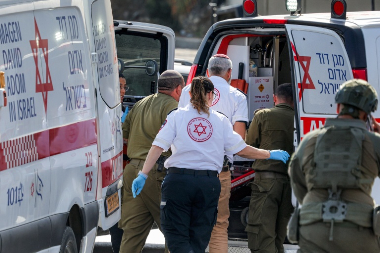Des secouristes israéliens prennent en charge un des cinq Israéliens blessés lors d'une attaque armée en Cisjordanie occupée, dont les deux auteurs ont été abattus, près de Hébron, le 23 octobre 2026 ( AFP / Ahmad GHARABLI )