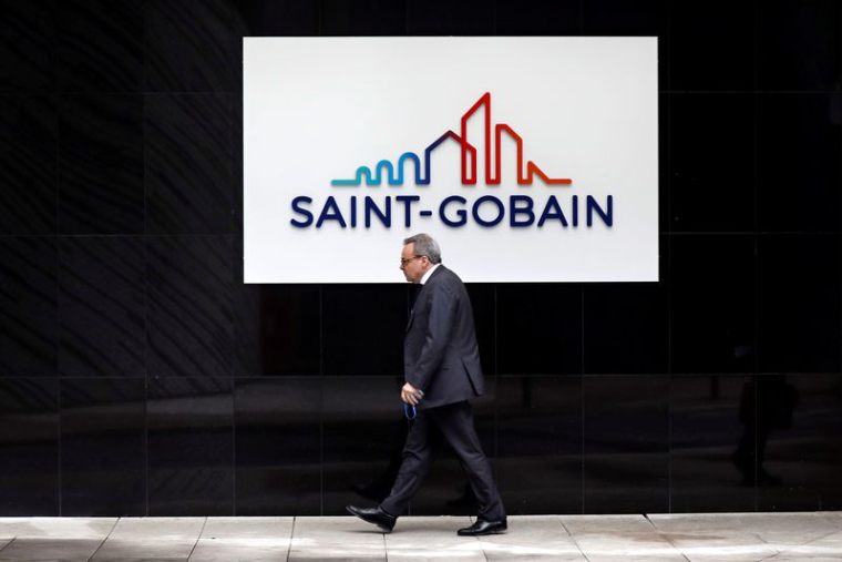 Un homme devant le logo de Saint-Gobain à La Défense