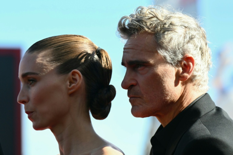 L'acteur et producteur américain Joaquin Phoenix et la comédienne Rooney Mara avant la projection du film "The Voice of Hind Rajab", en lice pour le Lion d'or de la 82ème Mostra de Venise, le 3 septembre 2025 ( AFP / Stefano RELLANDINI )