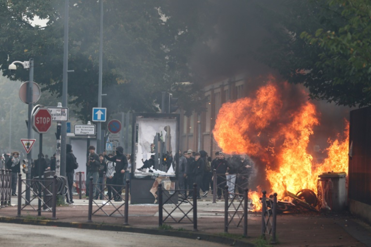 Une fumée noire s'élève des poubelles et des vélos en feu alors que des élèves mènent une action de blocage au collège César Baggio, le 29 septembre 2026 à Lille ( AFP / Sameer AL-DOUMY )