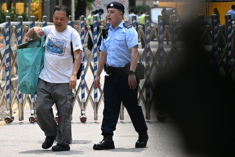 Steven Chong (gauche), un habitant de Wang Fuk Court, quitte son ancien immeuble avec des objets récupérés de son logement, le 20 avril 2026 à Hong Kong ( AFP / Peter PARKS )