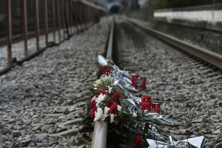 Des fleurs déposées sur les rails à la gare de Rapsani, dans le nord de la Grèce, le 5 mars 2023, lors d'un rassemblement en mémoire des victimes de l'accident de train qui a tué 57 persones en février à Tempe, dans le centre du pays ( AFP / Sakis MITROLIDIS )