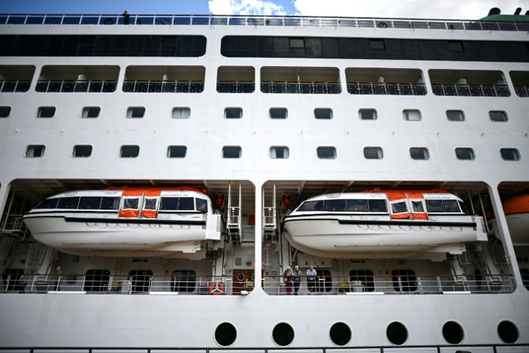 Des passagers du paquebot Ambition, confinés à bord dans le port de Bordeaux, le 13 mai 2026 en Gironde ( AFP / Christophe ARCHAMBAULT )