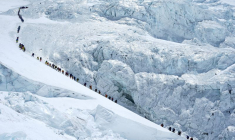 Des alpinistes marchent dans une longue file d'attente alors qu'ils se dirigent vers le sommet du mont Everest