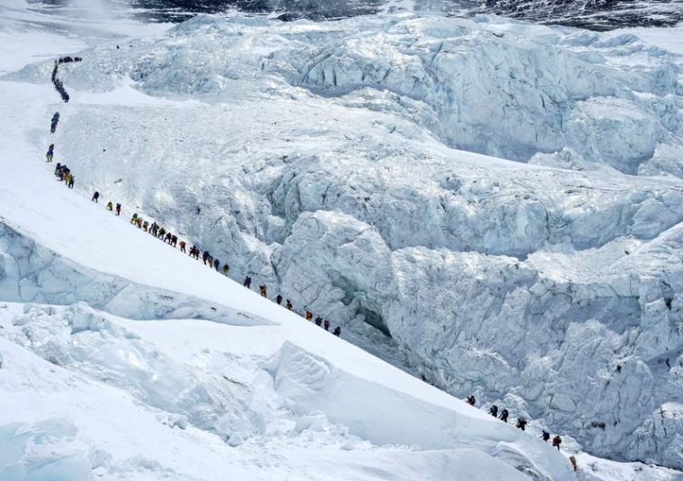 Des alpinistes marchent dans une longue file d'attente alors qu'ils se dirigent vers le sommet du mont Everest