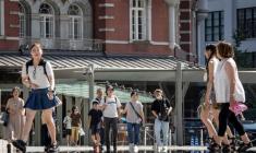 Des passants devant la gare de Tokyo un jour de chaleur le 27 août 2025 ( AFP / Yuichi YAMAZAKI )