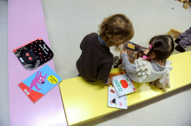 Des enfants de deux ans regardent un livre à Firmi, le 14 janvier 2013 ( AFP / ERIC CABANIS )