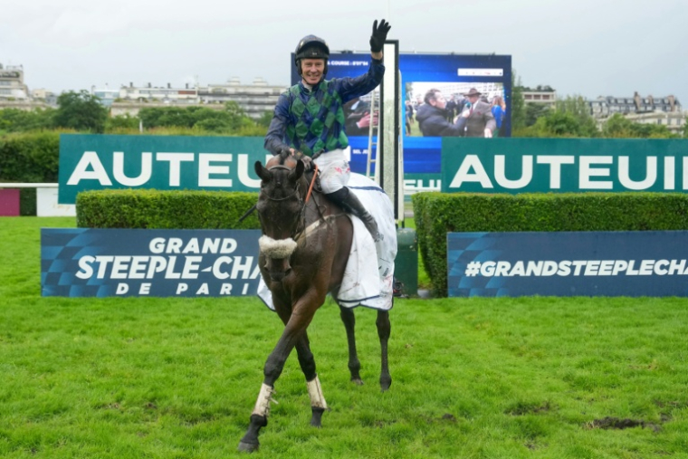 Le jockey français Johnny Charron célèbre sa victoire après avoir remporté le Grand Steeple-Chase de Paris 2026 à Auteuil, le 17 mai 2026 ( AFP / Dimitar DILKOFF )