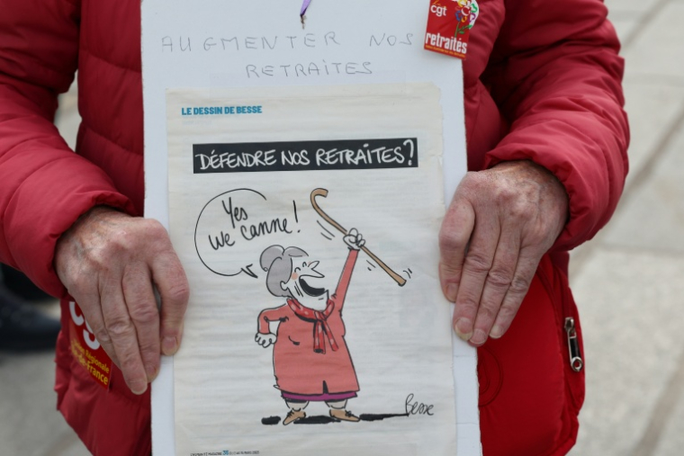 Dans la manifestation de retraités à l'appel des syndicats CGT, FSU et Solidaires pour une revalorisation "maximum" des pensions complémentaires, le 14 octobre 2026A protester holds a placard reading "Raise our pensions" and showing a cartoon of an elderly woman raising her cane, captioned "Defend our pensions?" and "Yes we cane!", as people gather at Place de la Bastille ahead of a march to the headquarters of supplementary pension scheme Agirc-Arrco, called by the CGT trade union to demand pensions be indexed to inflation after the 2026 freeze, in Paris, on October 14, 2026. ( AFP / MEHDI FEDOUACH )