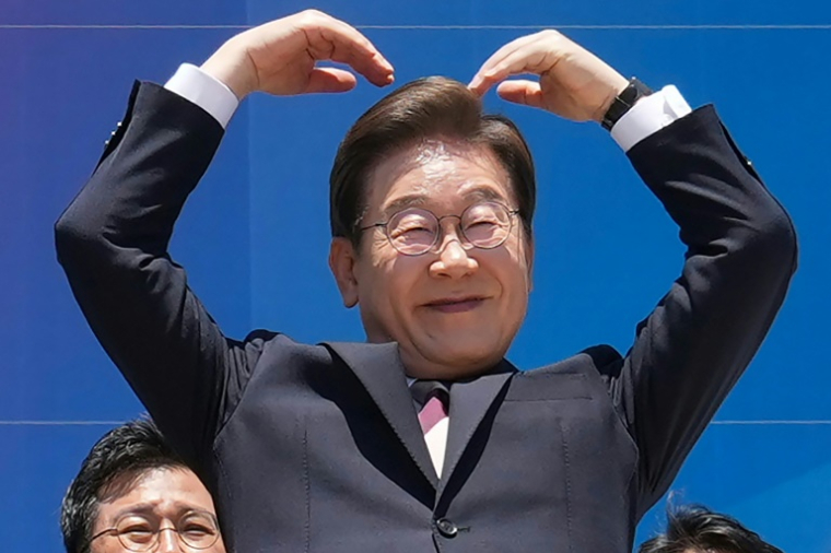 Le président sud-coréen Lee Jae-myung fait fait un cœur avec les bras à l'intention de ses partisans réunis devant l'Assemblée nationale, à Séoul, le 4 juin 2025 ( POOL / Lee Jin-man )