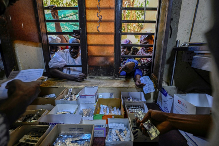 Photo montrant des Soudanais recevant des médicaments gratuits fournis par des bénévoles à l’hôpital Al-Nao d’Omdourman, le 18 avril 2026  ( AFP / Khaled DESOUKI )