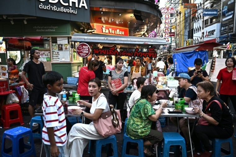 Des clients attablés dans un restaurant de rue, le 29 avril 2026 à Bangkok  ( AFP / Lillian SUWANRUMPHA )