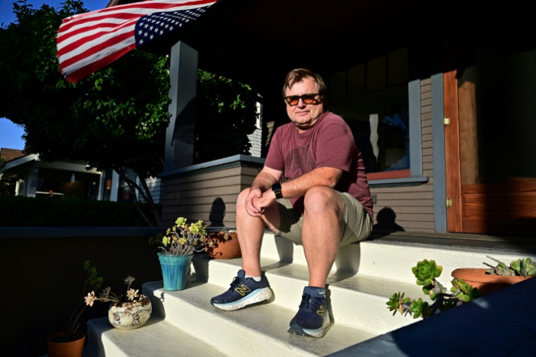 Patrick Bustad devant chez lui, dans un quartier de Los Angeles où une équipe de démarcheurs distribuent des prospectus en faveur du redécoupage électoral, le 22 octobre 2025 en Californie ( AFP / Frederic J. BROWN )