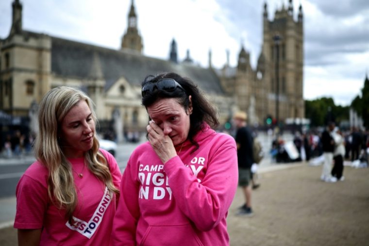 Des militants en faveur d'une modification de la loi sur l'aide à mourir réagissent après le rejet du projet de loi, devant le palais de Westminster, le 11 septembre 2026 à Londres ( AFP / Henry NICHOLLS )