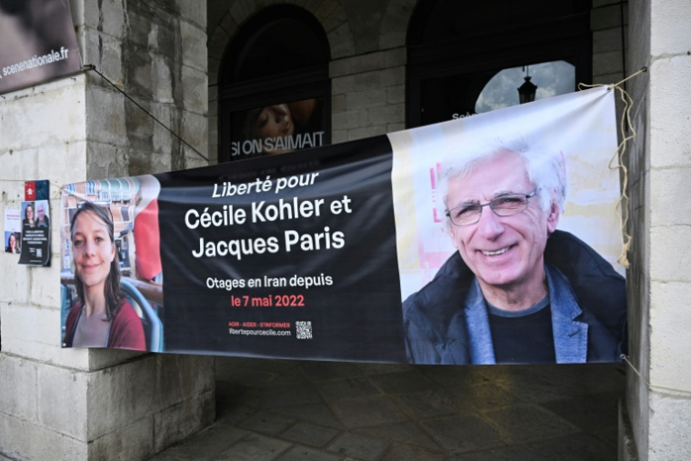 Une banderole représentant les Français Cécile Kholer et Jacques Paris détenus en Iran, lors d'un rassemblement pour leur libération, devant la mairie de Bayonne, le 7 mai 2025 ( AFP / Gaizka IROZ )