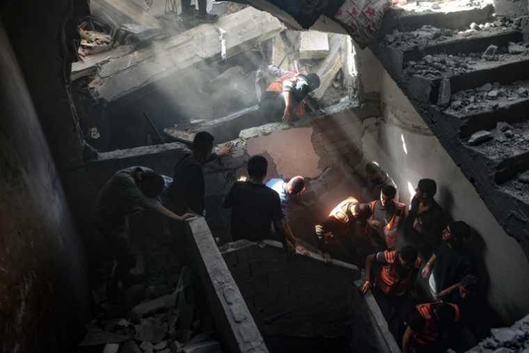 Des habitants et secouristes fouillent un immeuble touché par une frappe israélienne dans le quartier Shoujaiya de Gaza-ville, le 10 avril 2025 ( AFP / Omar AL-QATTAA )