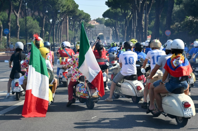 Des passionnés de Vespa du monde entier participent à la parade des Vespa World Days, marquant le 80e anniversaire de la célèbre marque italienne de scooters, le 27 juin 2026 à Rome  ( AFP / Alberto PIZZOLI )