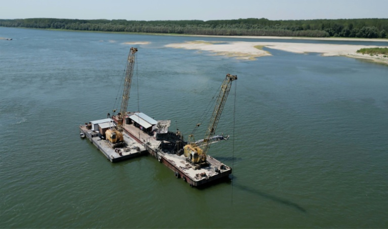 Deux dragueuses travaillent à approfondir le chenal navigable du Danube près du village de Cochirleni en Roumanie, le 12 août 2026 ( AFP / Daniel MIHAILESCU )